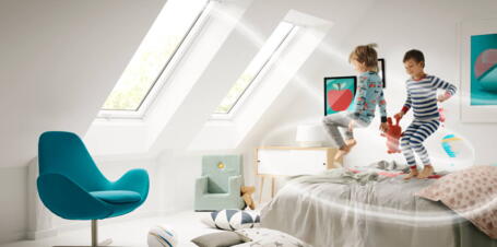 Kinder toben auf Bett im Kinderzimmer bei geöffnetem Fenster | VELUX Magazin