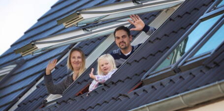 Familie guckt aus Dachfenstern des Kinderzimmers | VELUX Magazin
