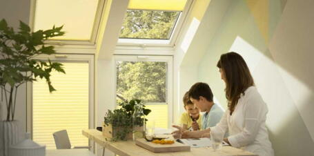 Familie am Frühstückstisch unter der Dachschräge mit Dachfenstern | VELUX Magazin