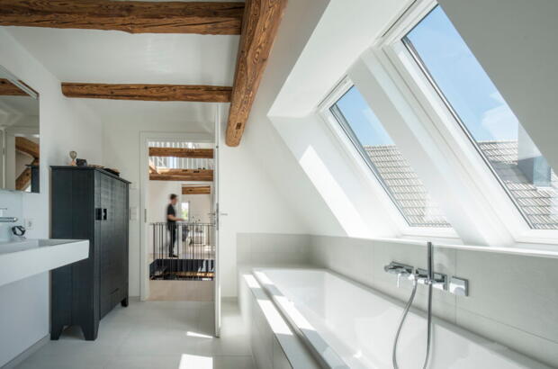 Badezimmer mit Holzbalken und zwei Dachfenstern - Velux Magazin
