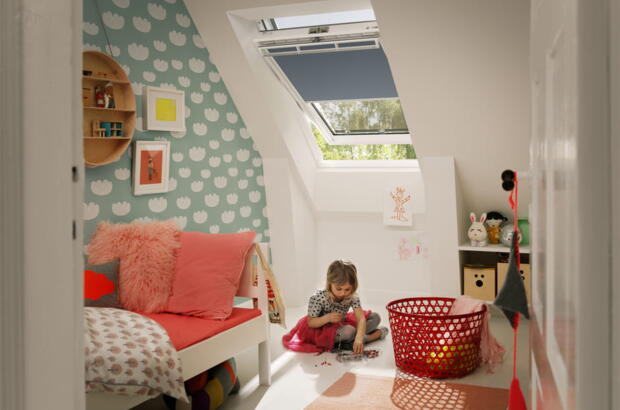 Mädchen sitzt im Kinderzimmer mit Dachfenster | VELUX Magazin