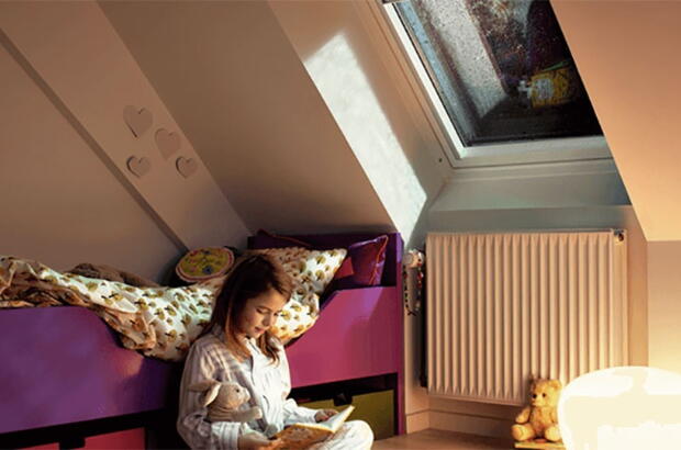 Kind liest Buch in Sitzecke unter Dachschräge | VELUX Magazin