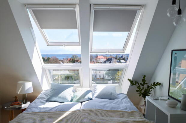 Schlafzimmer im Dachgeschoss mit dem Kopfende vom Bett unter Dachfenstern | VELUX Magazin
